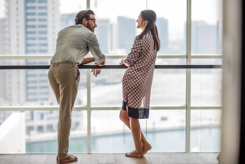 Couple échangeant devant la fenêtre d'une chambre d'hôtel à Dubaï – vivre à Dubaï en couple