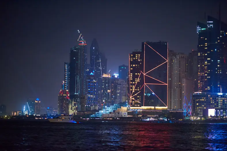 Dubai Marina la nuit avec bateaux touristiques colorés