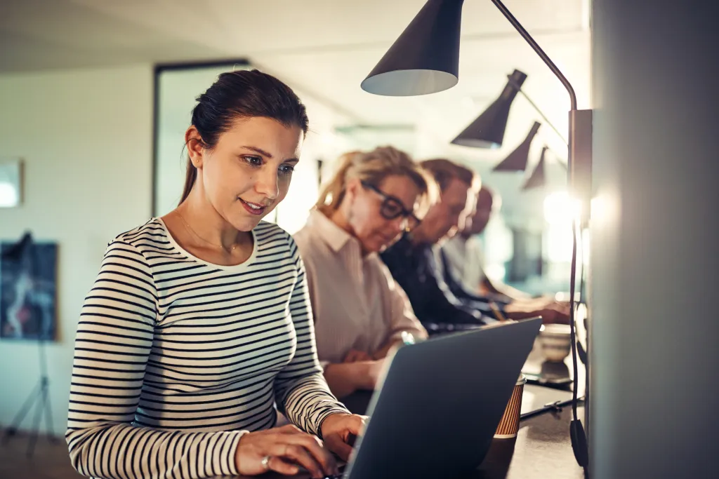 Femme souriante au bureau moderne, en train de chercher des opportunités professionnelles à Dubaï.