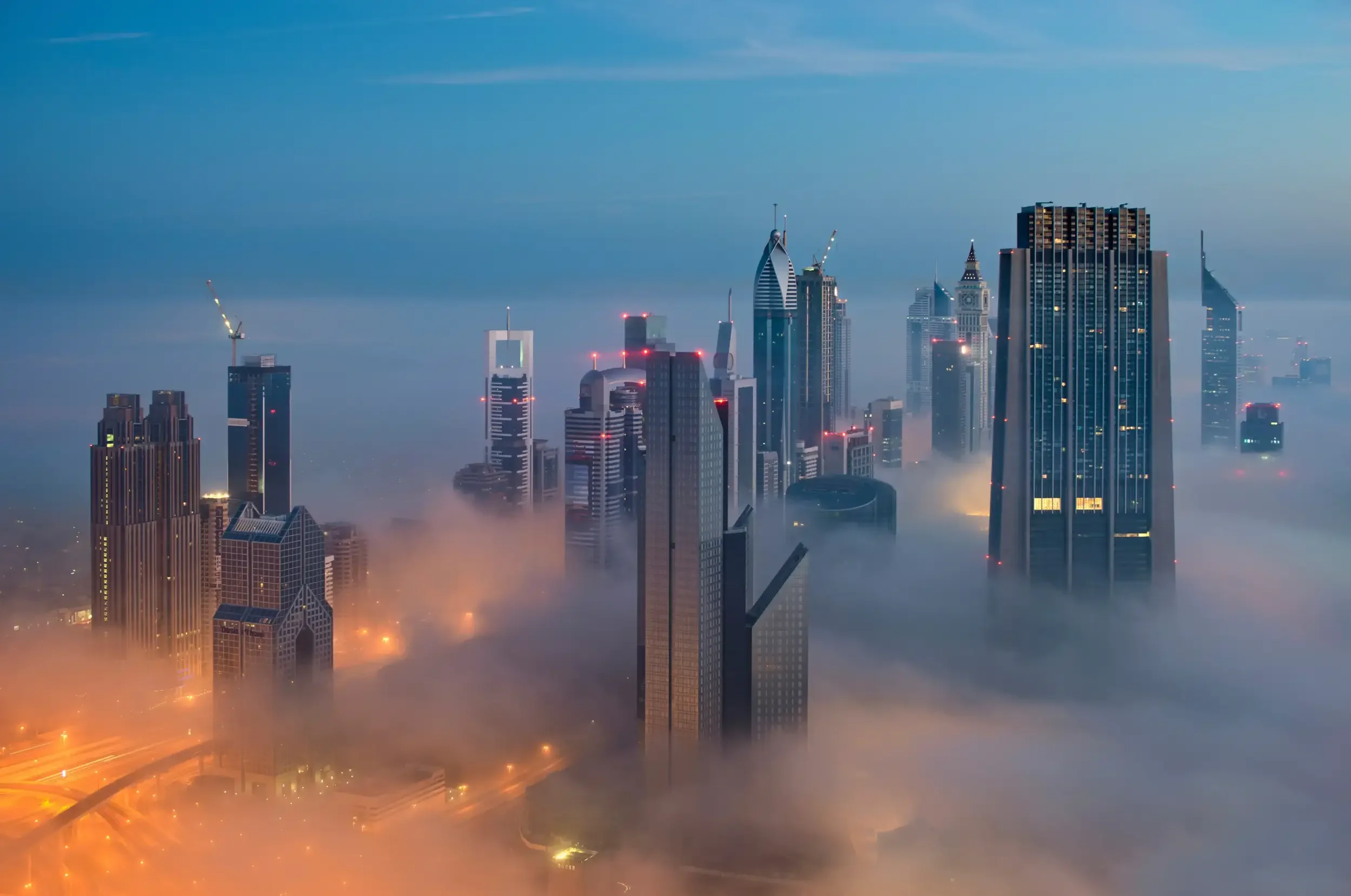 Skyline de gratte-ciel plongés dans le brouillard au petit matin Gratte-ciel éclairés au-dessus du brouillard dans une grande ville moderne