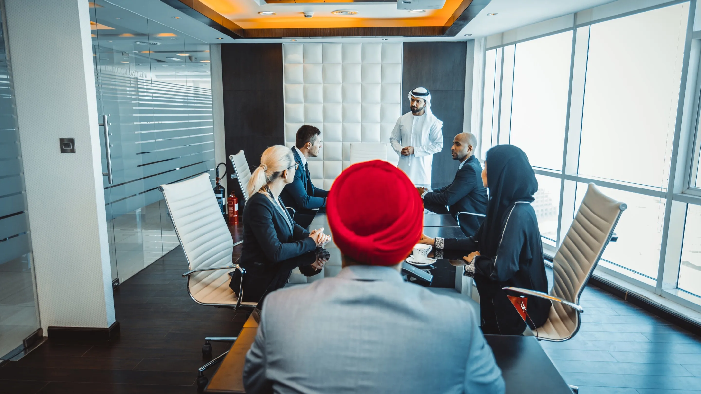 Réunion d’affaires dans un bureau à Dubaï : un Émirati présente un projet à une équipe internationale