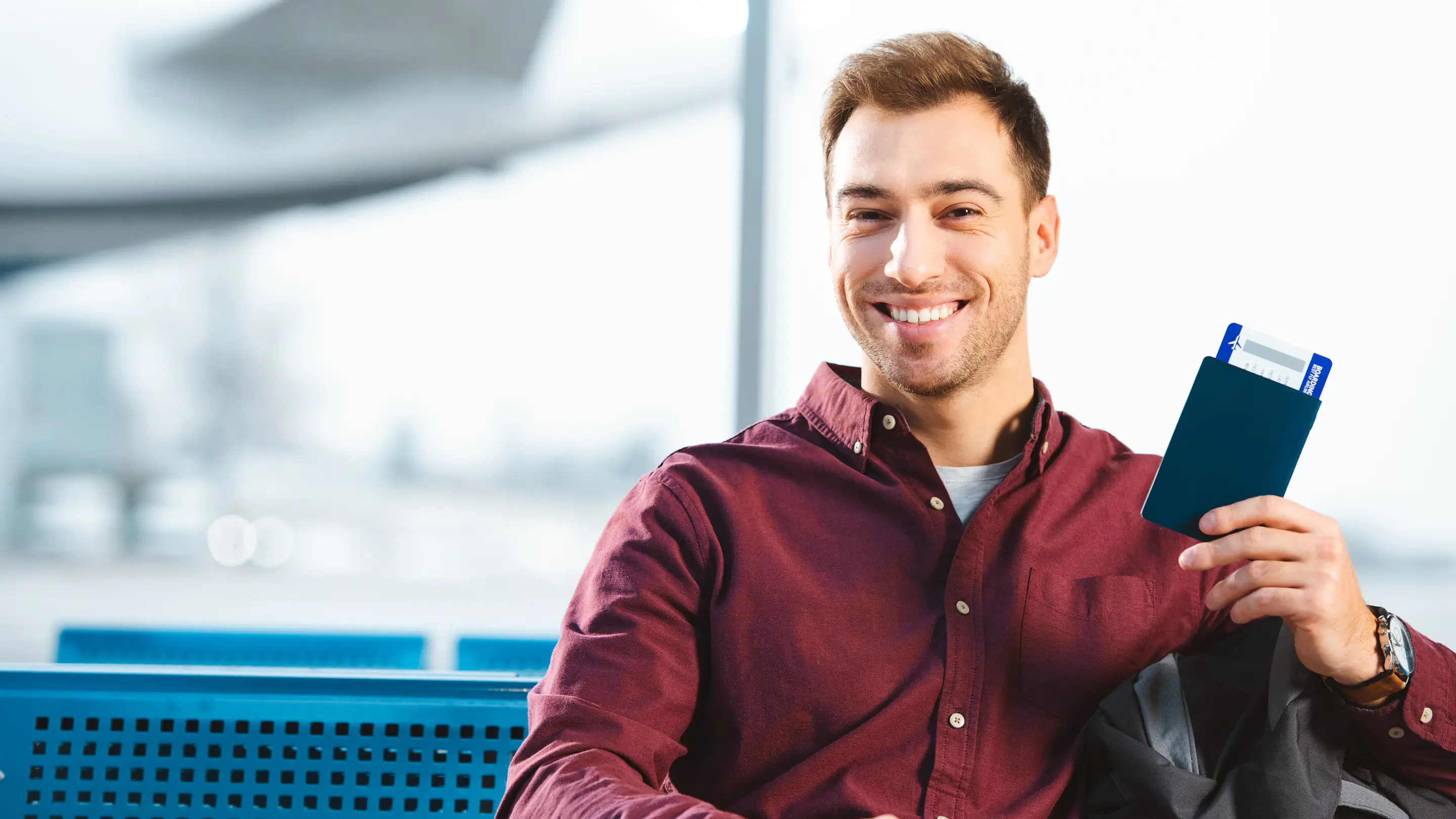 Homme tenant son passeport et son billet d’avion