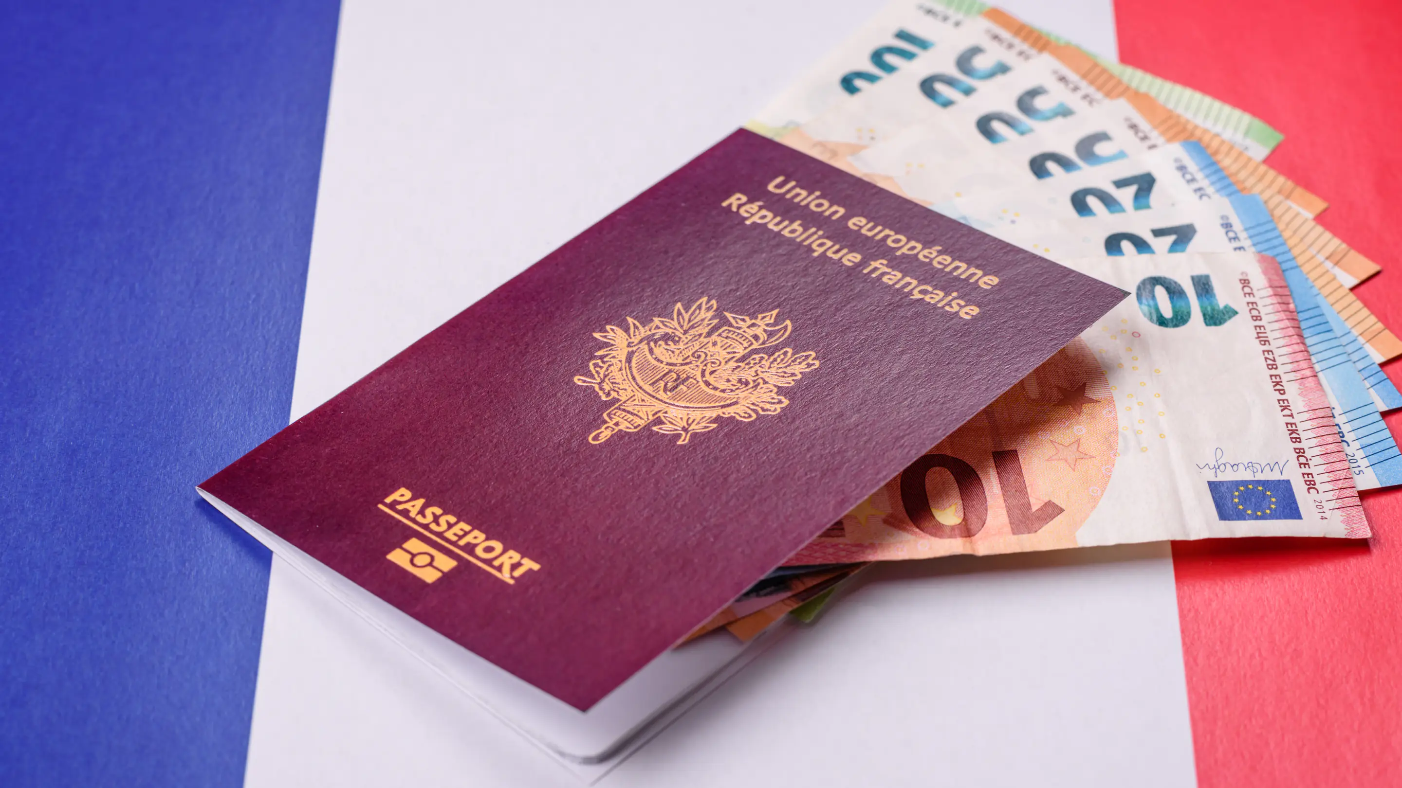 Passeport français et billets sur le drapeau français