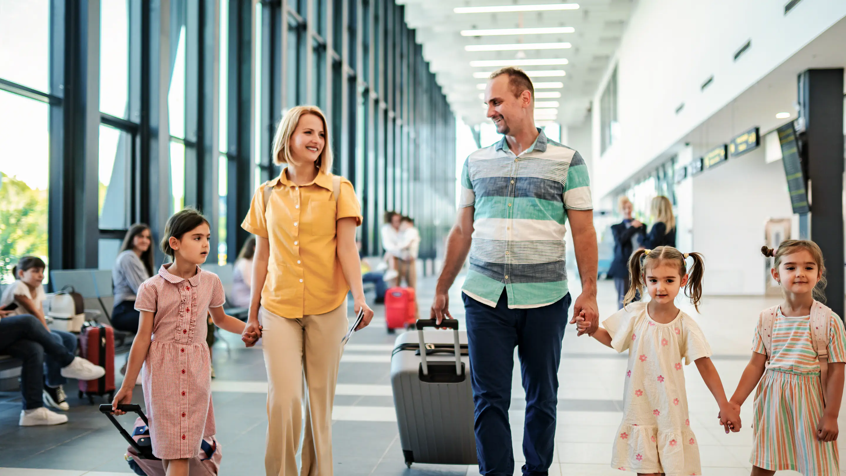 Famille heureuse traversant un terminal d’aéroport