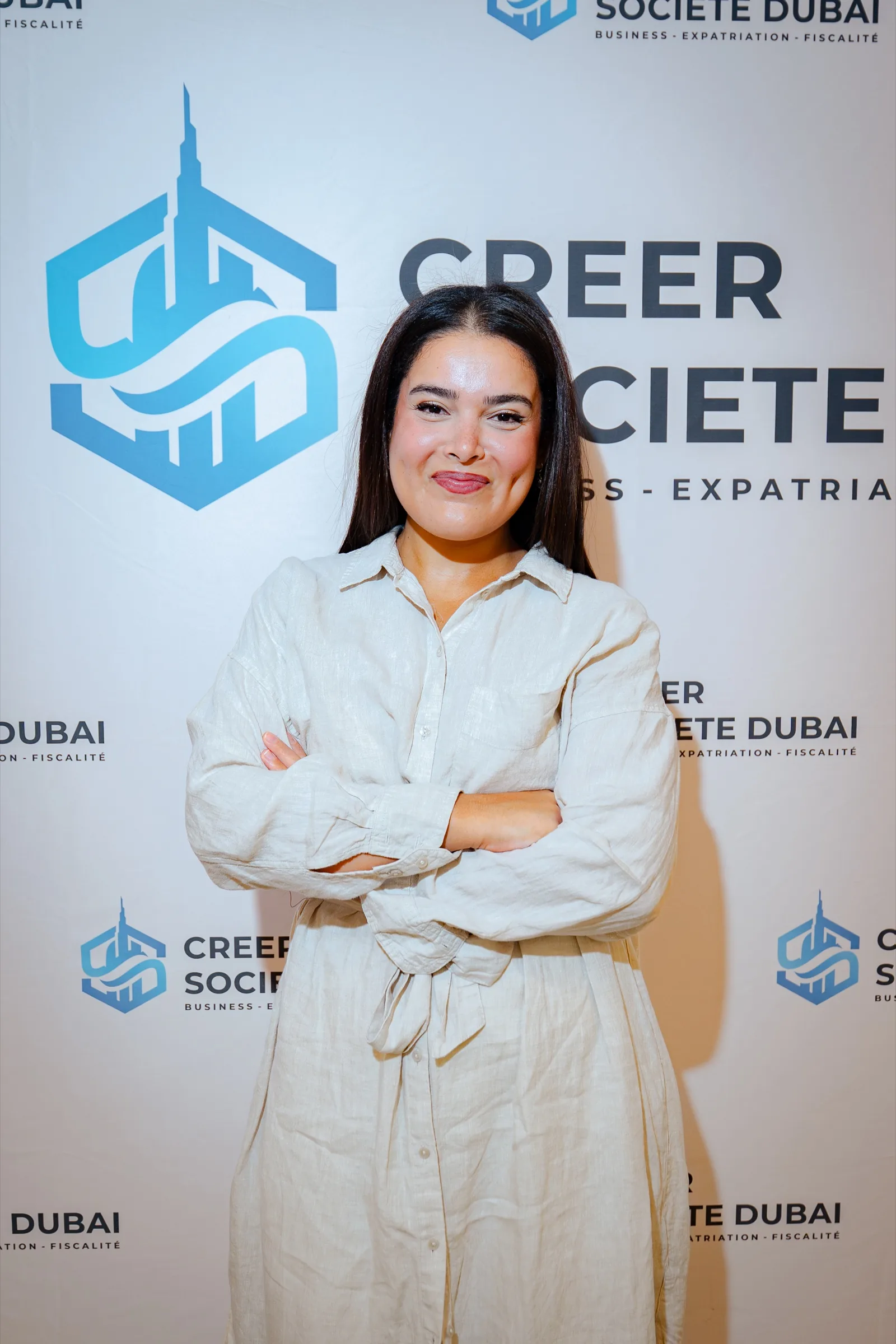 Participante devant le mur logo Créer Société Dubai lors d'un Improving Days